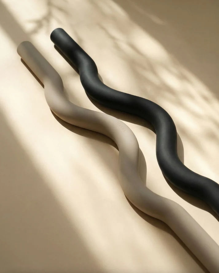 Muna Long Dumbbell Beam in sleek design, showcasing the black and beige colors on a textured background.