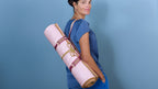 Woman carrying a Holistic Silk Yoga Rug Mat, showcasing its luxury design and functionality for yoga enthusiasts.