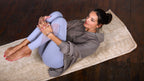 Woman practicing yoga poses on a Holistic Silk luxury Yoga Rug Mat, demonstrating flexibility and relaxation.