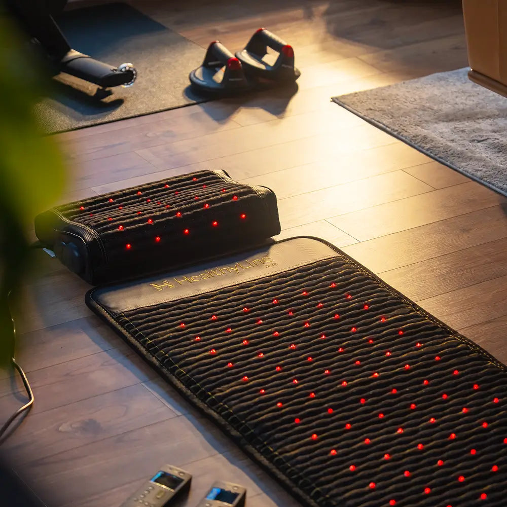 PEMF Far Infrared Heating Mat placed on wooden floor with accessories in a cozy room.