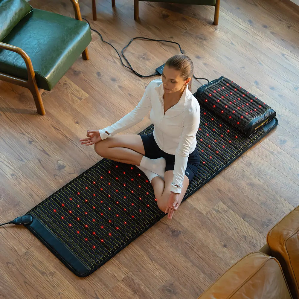 A woman practicing meditation on the Healthyline PEMF Far Infrared Heating Mat in a cozy indoor setting.