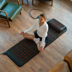 A woman practicing meditation on the Healthyline PEMF Far Infrared Heating Mat in a cozy indoor setting.