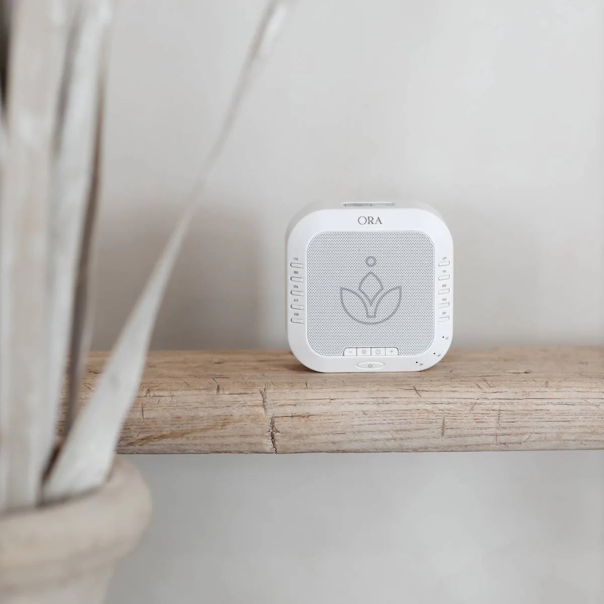 ORA Sound Frequency Machine on wooden shelf designed for calming sound therapy and relaxation.
