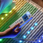 Person holding the controller for HealthyLine Rainbow Chakra PEMF Far Infrared Heating Mat with colorful lights.