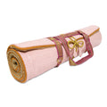 Holistic Silk luxury Yoga Rug Mat rolled up with a vibrant strap, perfect for yoga enthusiasts.