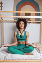 Woman meditating with Sensate vagus nerve toning device for stress relief and relaxation.