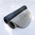 Muna oval yoga mat in black and gray colors, showcasing a comfortable design for various movement practices.